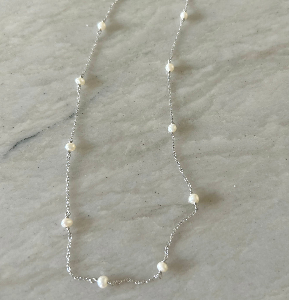 June Simple Pearl Necklace by Pearly Girls, embodying timeless elegance on a sterling silver chain. This necklace features a single, lustrous pearl delicately suspended on a fine sterling silver chain, offering a minimalist yet classic look that highlights the pearl's natural beauty.