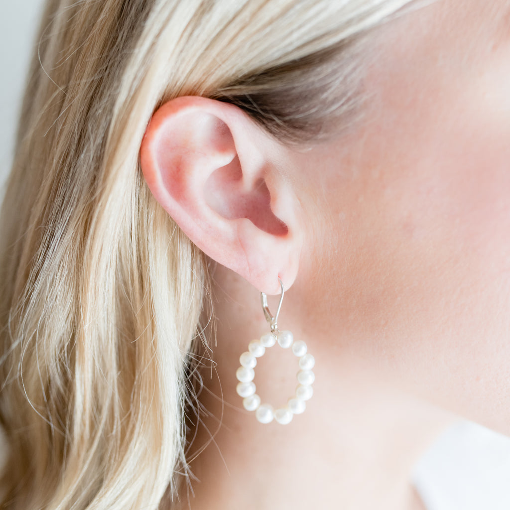 Oval Pearl Hoop Earrings by Pearly Girls, showcasing freshwater pearl elegance. These earrings feature a modern oval hoop design, adorned with lustrous freshwater pearls, creating a piece that combines contemporary style with the classic beauty of pearls.