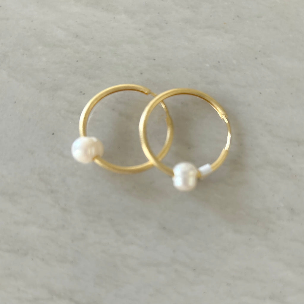 Gold-Plated Small Hoops and Pearl Earrings by Pearly Girls, a perfect blend of timeless elegance and contemporary style. These earrings feature sleek, gold-plated hoops paired with classic pearl accents, combining the enduring charm of pearls with a modern hoop design for a versatile and chic look.
