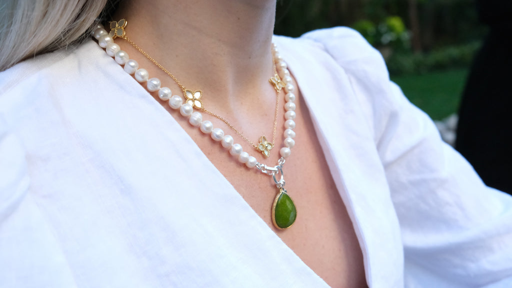 Mother of Pearl Flower Necklace by Pearly Girls, a gold pearl necklace. This necklace features a delicate Mother of Pearl flower, exuding a natural iridescence and elegance, paired with the warm glow of gold pearls, creating a piece that blends botanical beauty with classic sophistication.