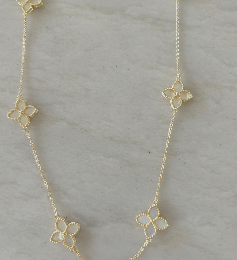 Mother of Pearl Flower Necklace by Pearly Girls, a gold pearl necklace. This necklace features a delicate Mother of Pearl flower, exuding a natural iridescence and elegance, paired with the warm glow of gold pearls, creating a piece that blends botanical beauty with classic sophistication.