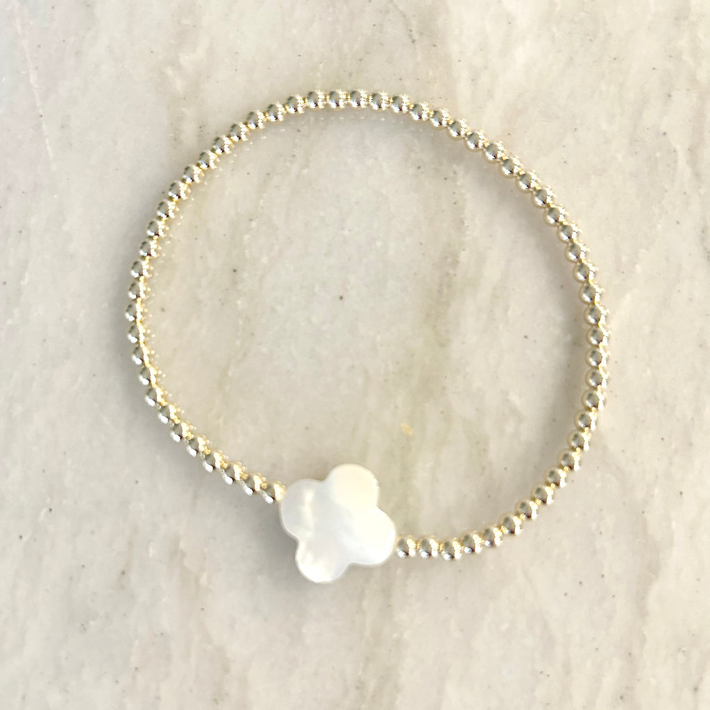 Clover Bracelet by Pearly Girls, featuring gold beads and a Mother of Pearl clover. This bracelet elegantly combines the shimmer of gold beads with the delicate charm of a Mother of Pearl clover, creating a piece that's both stylish and symbolic of good fortune.