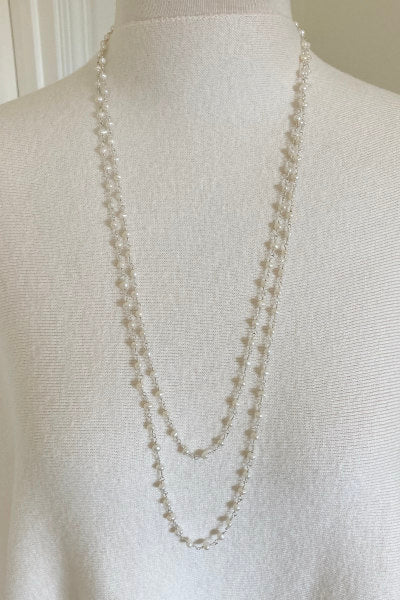 Classic Amelia pearl necklace by Pearly Girls, featuring a 60-inch strand of freshwater white round pearls. This versatile piece exudes elegance and can be styled in multiple ways, perfect for adding a touch of timeless sophistication to any outfit.