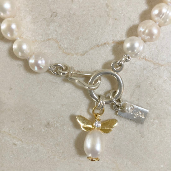 Bea Pearl Bracelet by Pearly Girls features white freshwater nugget pearls paired with a charming bee charm. This bracelet combines the natural, organic shapes of nugget pearls with a playful and intricately designed bee charm, creating a unique and whimsical accessory.