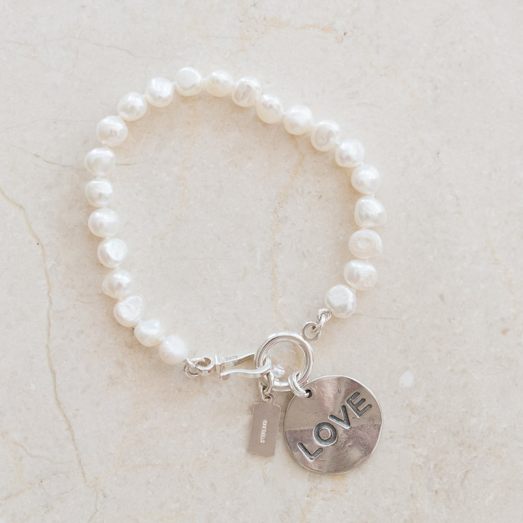 Cupid Pearl Bracelet by Pearly Girls, combining freshwater nugget pearls with a sterling silver LOVE disc. This bracelet artfully marries the organic charm of nugget pearls with the romantic symbolism of the LOVE disc, creating a heartfelt and stylish piece.