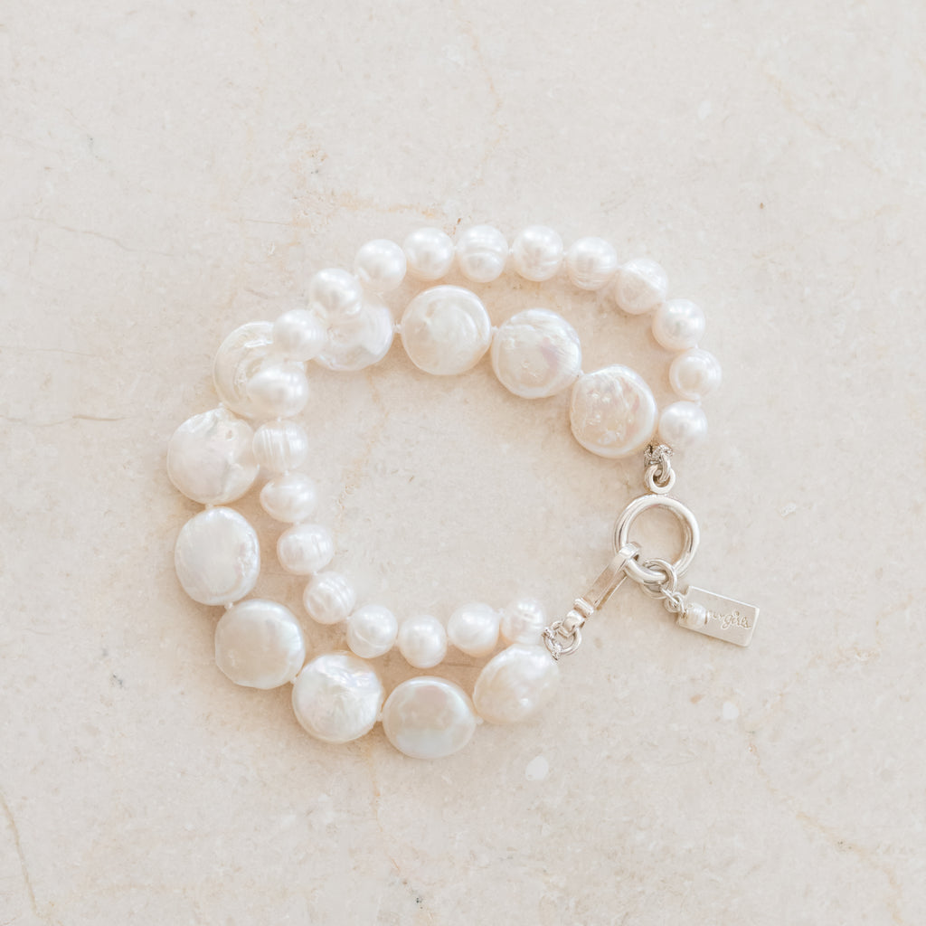 Chloe Pearl Bracelet by Pearly Girls, a double strand pearl bracelet. This piece elegantly layers two strands of lustrous pearls, creating a sophisticated and timeless look that enhances the charm and elegance of classic pearl jewelry.