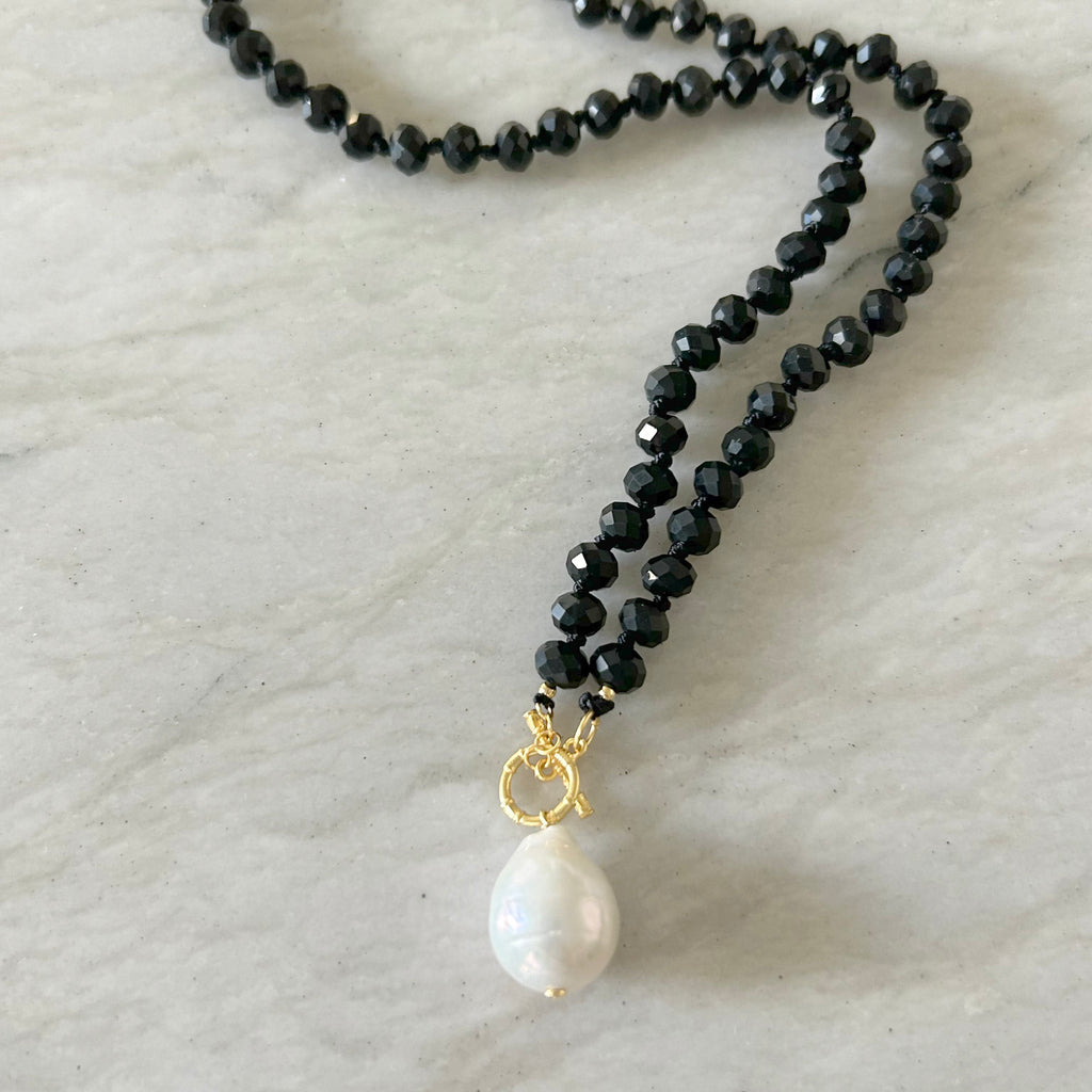Black Spinels Necklace by Pearly Girls, showcasing a luxurious faceted design with a freshwater pearl accent. This necklace features sparkling black spinel stones, complemented by a single, lustrous freshwater pearl, blending contemporary elegance with classic sophistication.
