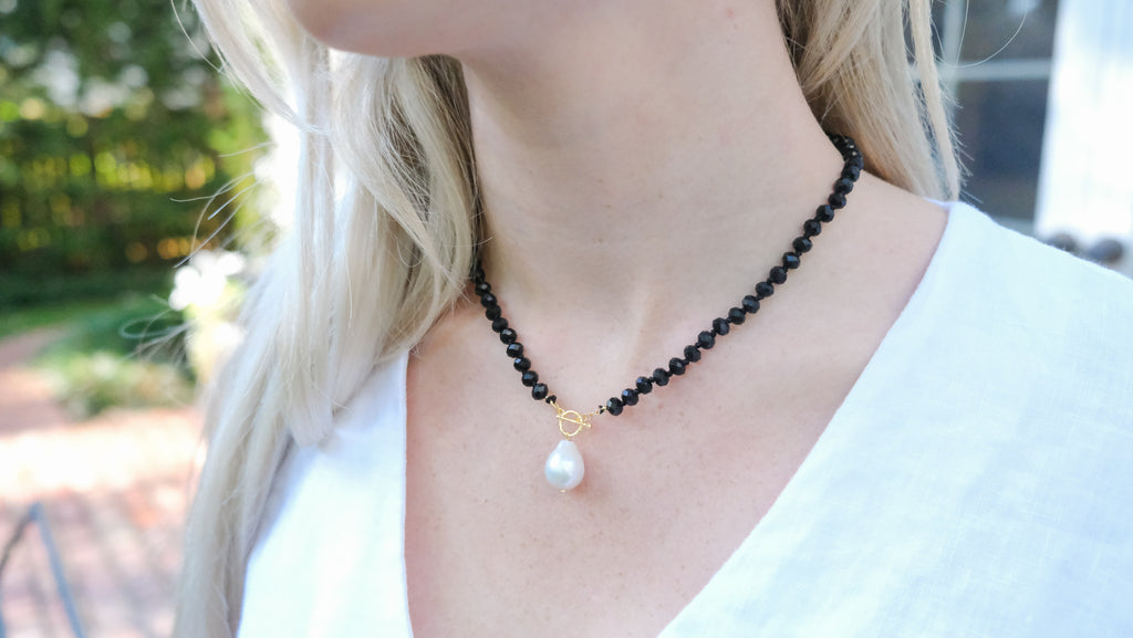 Black Spinels Necklace by Pearly Girls, showcasing a luxurious faceted design with a freshwater pearl accent. This necklace features sparkling black spinel stones, complemented by a single, lustrous freshwater pearl, blending contemporary elegance with classic sophistication.