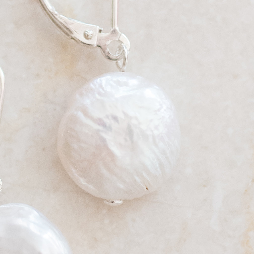 Coin Pearl Earrings by Pearly Girls, showcasing freshwater elegance with a secure design. These earrings feature the distinct shape of coin pearls, combining their unique, flat elegance with a robust and reliable construction for a blend of beauty and practicality.