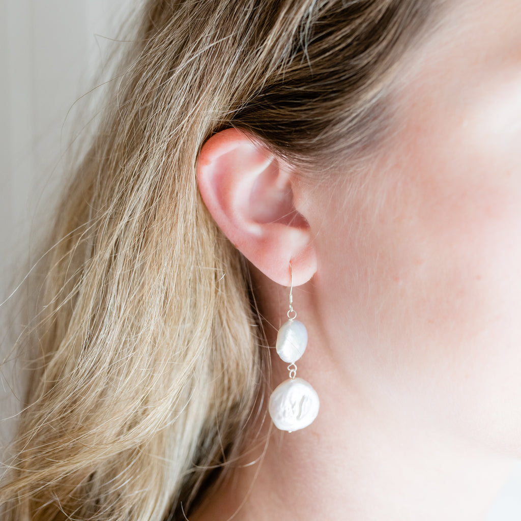 Double Coin Pearl Earrings by Pearly Girls, showcasing luminescent elegance with a double coin cascade. These earrings feature two layers of coin pearls, known for their unique, flat shape and lustrous sheen, creating a cascading effect that adds a touch of sophistication and modern flair.