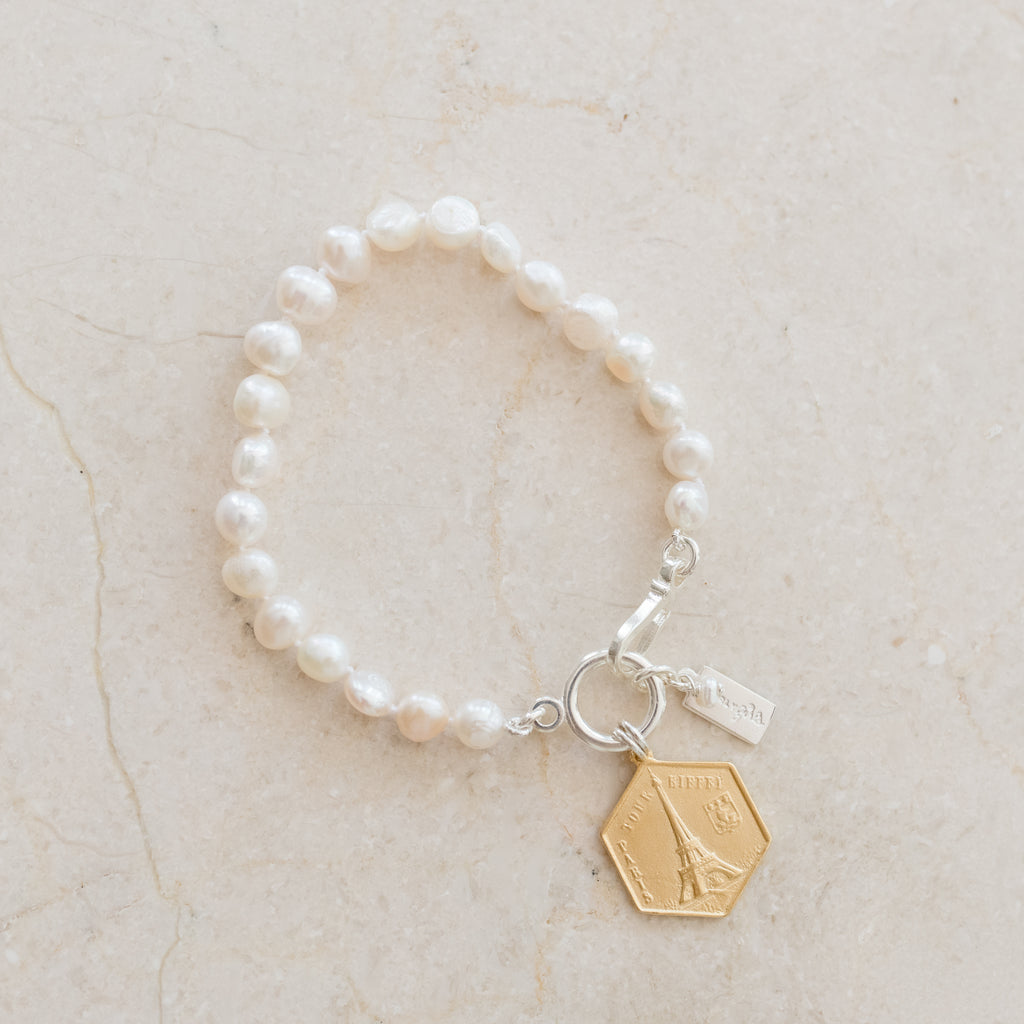 Maeve Pearl Bracelet by Pearly Girls, featuring an Eiffel Tower charm and freshwater pearls. This bracelet combines the romantic allure of an Eiffel Tower charm with the timeless elegance of freshwater pearls, creating a piece that's both charming and classic, evoking a sense of Parisian chic.