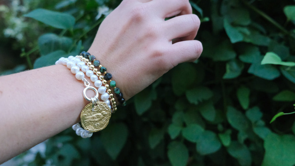 Callie Pearl Bracelet by Pearly Girls features nature-inspired elegance with a gold bird charm. This bracelet blends the classic beauty of pearls with the delicate intricacy of a gold bird charm, creating a piece that's both graceful and symbolic of freedom and serenity.