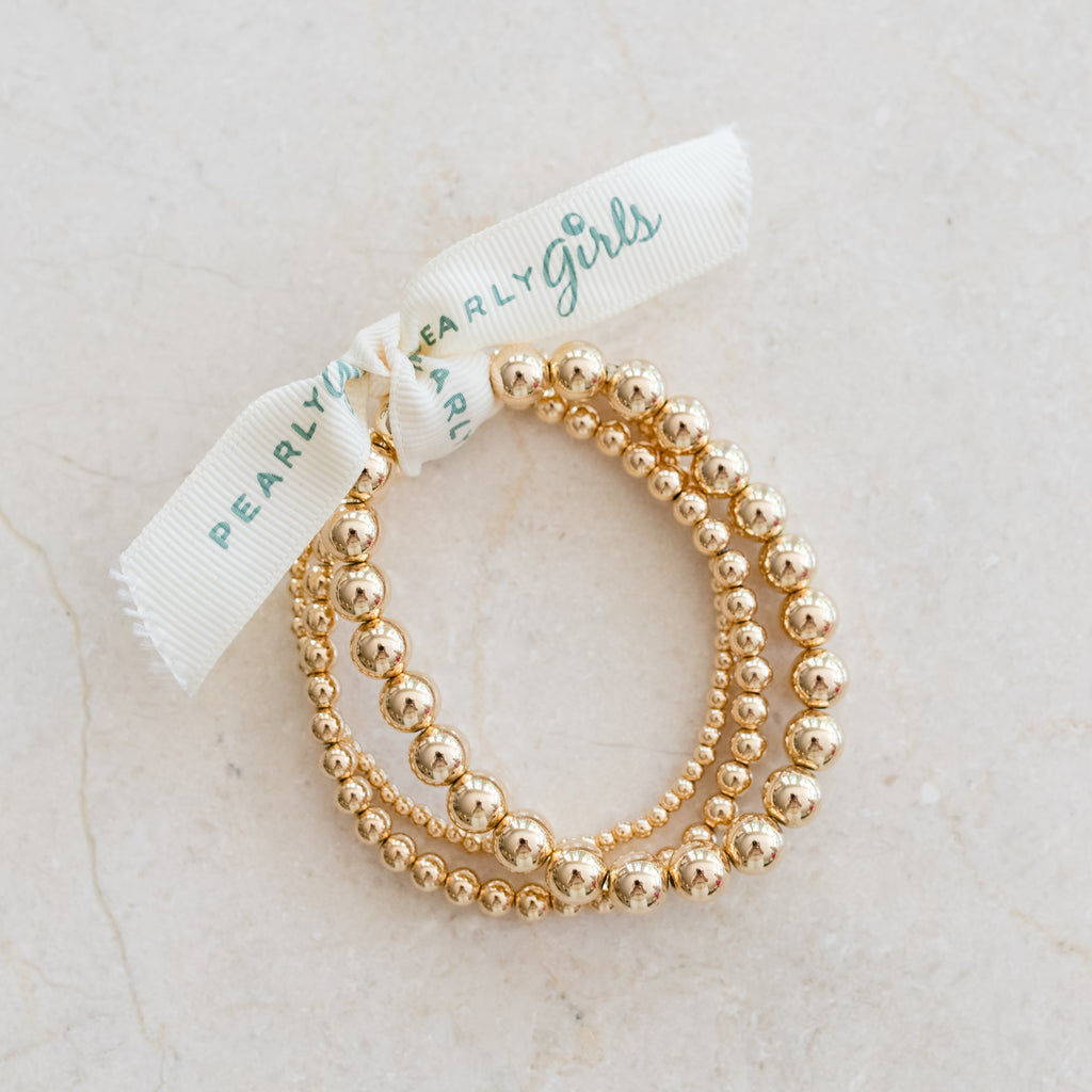 Gold-Filled Stretchy Bracelets by Pearly Girls, epitomizing versatile elegance with customizable style. These bracelets feature the luxury of gold-filled material in a flexible, stretchy design, allowing for a comfortable fit and the option to personalize or layer for a unique, fashionable look.
