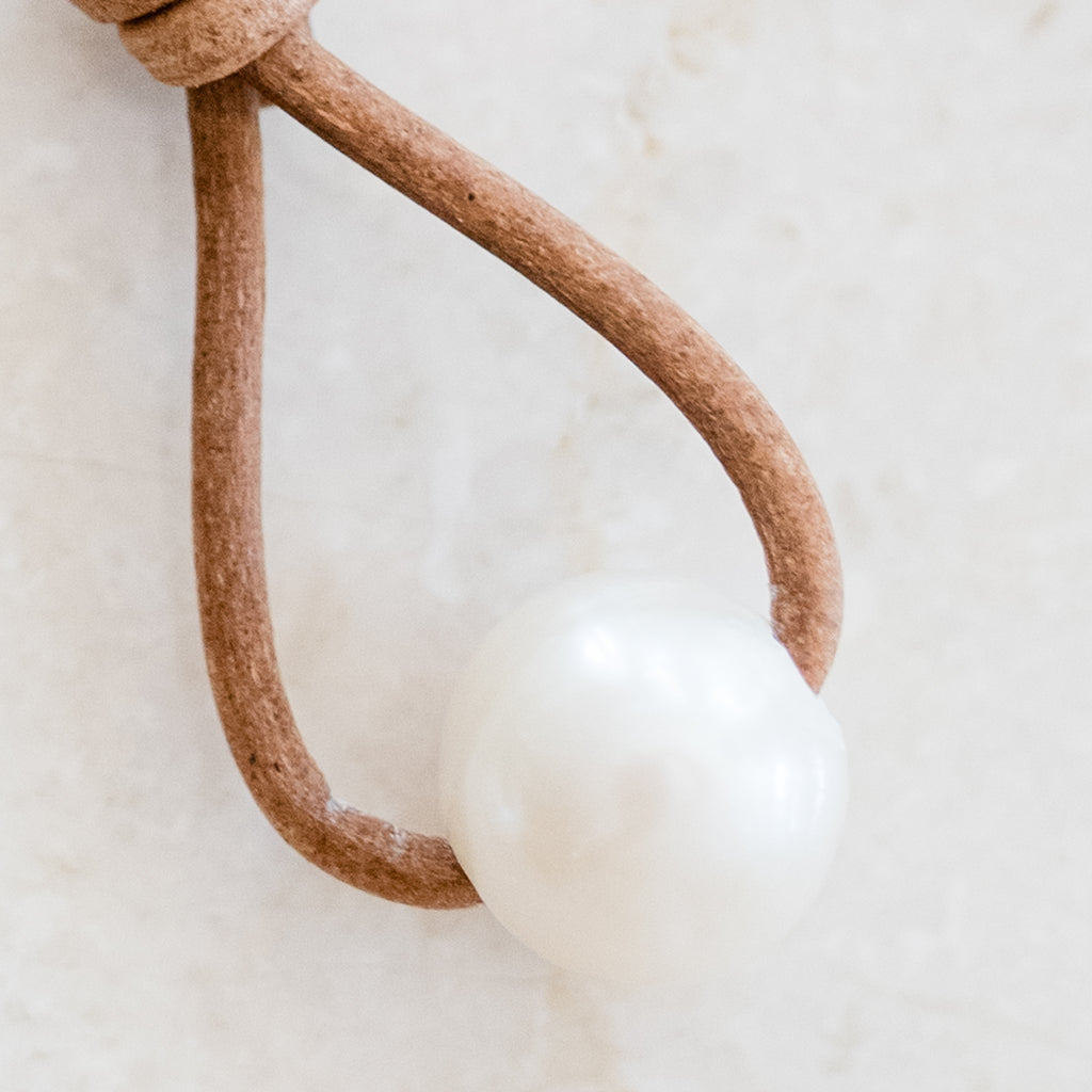 Leather and Pearl Earrings by Pearly Girls, featuring knotted leather and timeless pearls. These earrings creatively combine the rugged, organic feel of knotted leather with the classic elegance of pearls, creating a unique accessory that blends contrasting textures and styles.