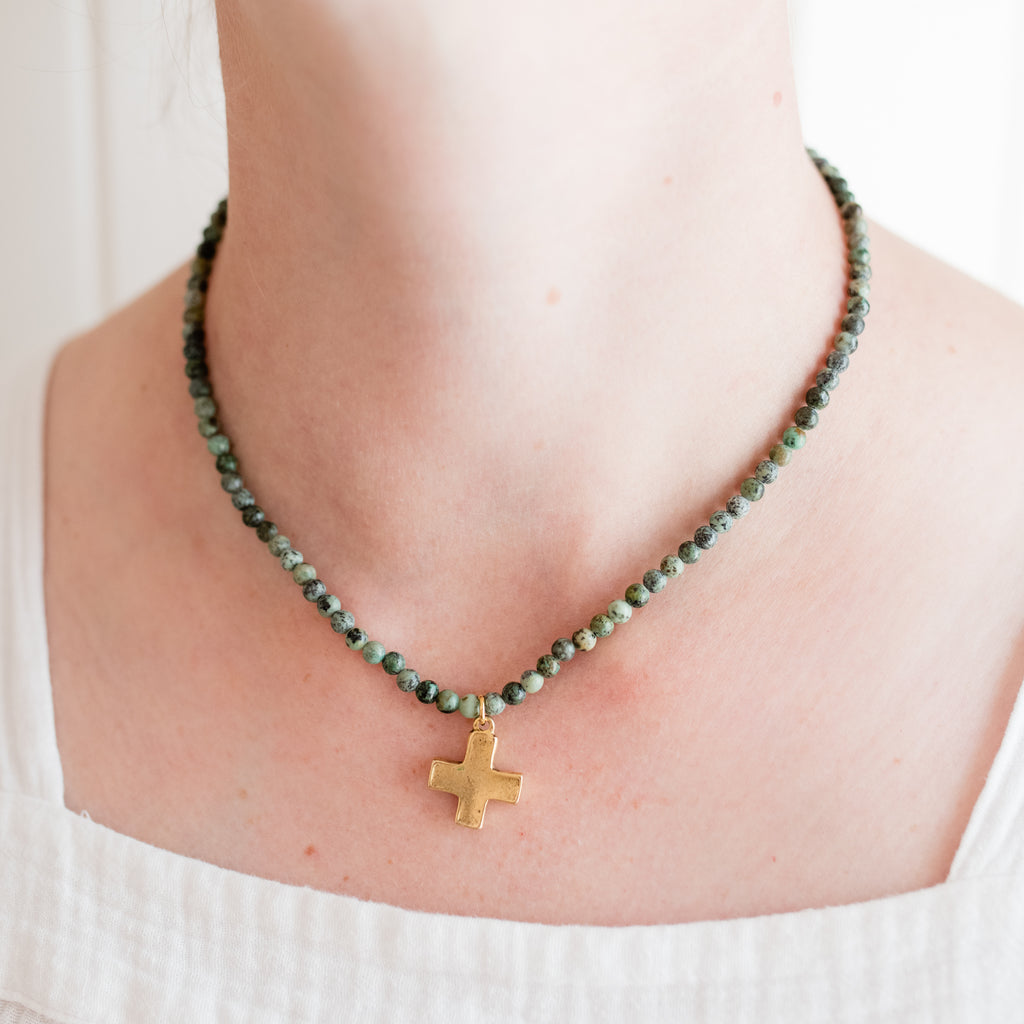 Marty African Turquoise Necklace by Pearly Girls, featuring vibrant gemstones and a chunky gold cross. This necklace combines the rich, earthy tones of African turquoise beads with a bold gold cross, creating a striking contrast and a statement piece that blends natural elegance with a touch of boldness.