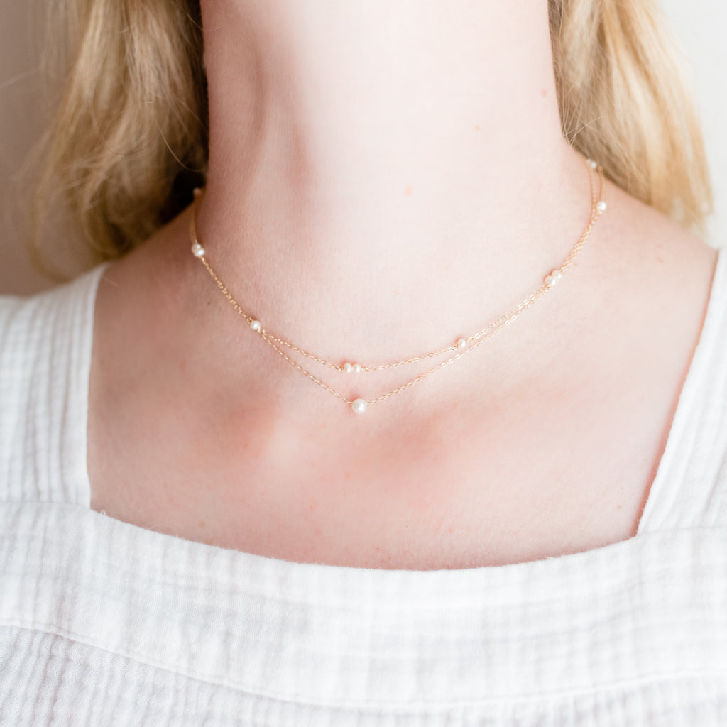 Megan Gold-Filled Necklace by Pearly Girls, a subtle elegance freshwater pearl necklace. This piece showcases the delicate charm of freshwater pearls, complemented by the warmth of a gold-filled setting, offering a refined and understated accessory that embodies classic pearl elegance.