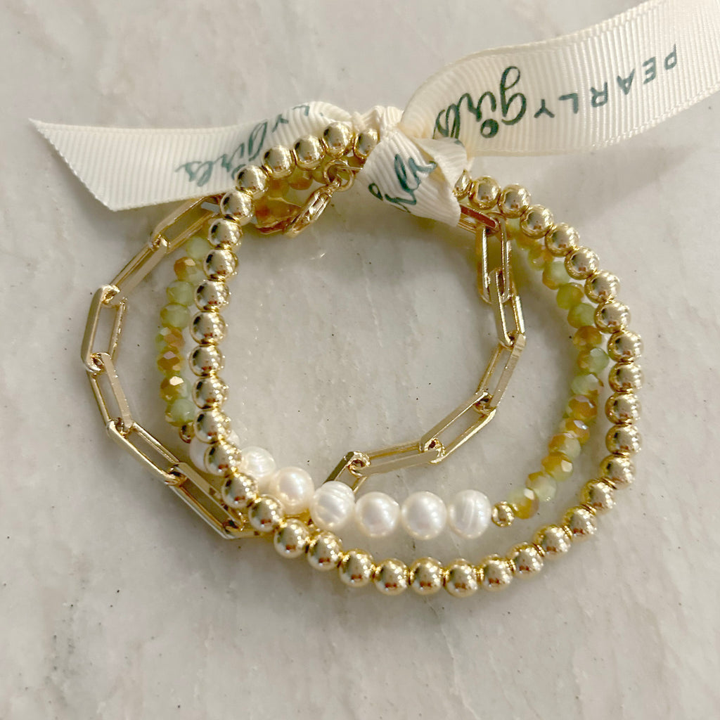 Paper Clip and Pearl Bundle by Pearly Girls, featuring gold-filled and green gemstone bracelets. This bundle combines the modern appeal of gold-filled paper clip bracelets with the timeless elegance of pearls, accented by the vibrant touch of green gemstones, creating a stylish and versatile collection.