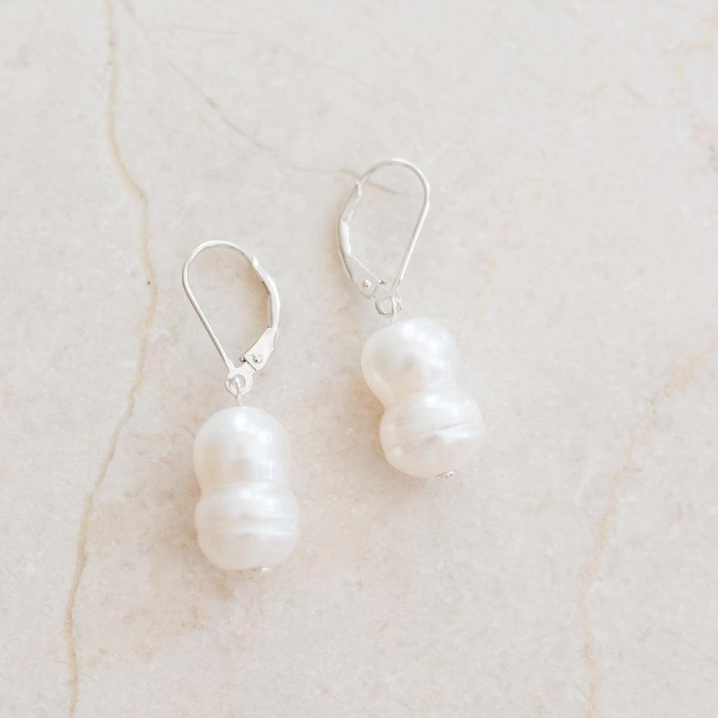 Peanut Pearl Earrings by Pearly Girls, featuring a unique freshwater pearl design. These earrings showcase an intriguing peanut-shaped pearl, offering a distinct and novel take on traditional pearl jewelry, blending the natural irregularity of pearls with an element of whimsical charm.
