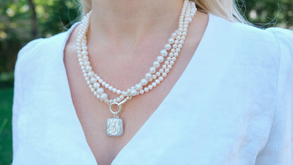 Willa Pearl Necklace by Pearly Girls, showcasing festive elegance with a Mother of Pearl pendant. This necklace combines the lustrous beauty of pearls with the iridescent charm of a Mother of Pearl pendant, creating a piece that is both celebratory and gracefully refined.
