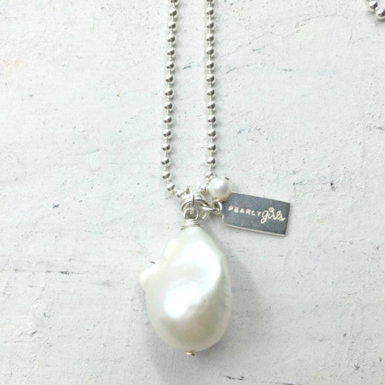 Julie Pearl Necklace by Pearly Girls, showcasing a freshwater fireball pearl pendant. This necklace features a striking fireball pearl with its unique shape and lustrous sheen, creating a focal point of natural elegance and sophisticated charm in a classic pearl necklace design.