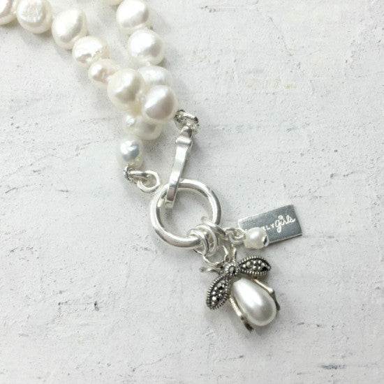 Betsy Pearl Necklace by Pearly Girls, featuring a bee charm and nugget pearls. This necklace artfully combines irregularly shaped nugget pearls with a delicately crafted bee charm, creating a harmonious balance between natural beauty and charming design.