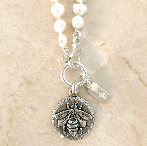 Lydia Silver Pearl Necklace by Pearly Girls, featuring a bee motif and freshwater pearls. This necklace harmoniously combines the natural elegance of freshwater pearls with a charming silver bee motif, creating a piece that is both stylish and symbolic of nature's beauty.