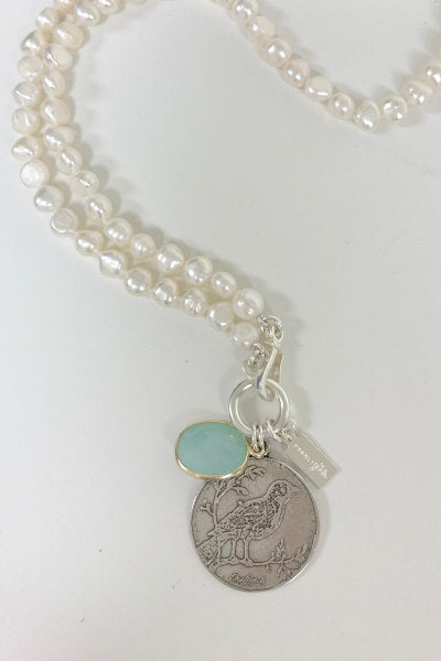 Kathryn Pearl Necklace by Pearly Girls, a long white nugget pearl necklace with a silver bird pendant. This necklace combines the organic charm of white nugget pearls with the delicate detail of a silver bird pendant, creating a piece that's both elegant and whimsically inspired.