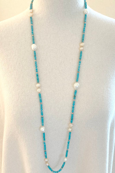 Veronica Turquoise Magnasite & Pearl Necklace by Pearly Girls, featuring a 36" versatile length. This necklace artfully blends the bold, vibrant hues of turquoise magnasite with the classic elegance of pearls, offering a long, versatile piece that can be styled in various ways for different occasions.