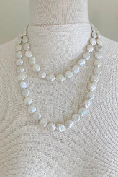 Flat Coin Pearl Necklace by Pearly Girls, characterized by iridescent elegance and available in versatile lengths. This necklace highlights the unique, flat profile of coin pearls, offering a contemporary twist on traditional pearl elegance, adaptable for various styles and occasions.