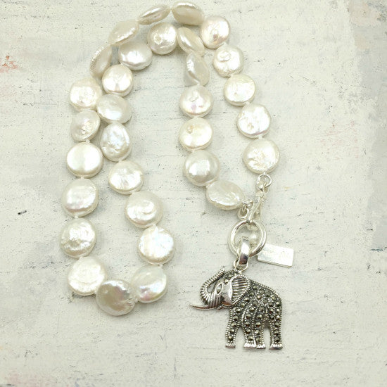 Michelle Pearl Necklace by Pearly Girls, featuring an elephant charm and flat coin pearls. This necklace artfully combines the unique, broad shape of flat coin pearls with a charming elephant pendant, creating a piece that's both elegant and symbolic, embodying strength and wisdom.