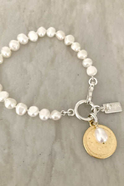 Emily Pearl Bracelet by Pearly Girls, featuring freshwater nugget pearls and a reversible coin pendant. This bracelet showcases the organic beauty of nugget pearls paired with the versatility of a reversible coin pendant, offering a unique and stylish piece adaptable to different looks and occasions.