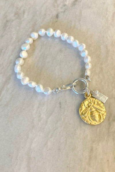 Lydia Gold Pearl Bracelet by Pearly Girls, featuring a whimsical bee charm and timeless pearls. This bracelet elegantly pairs lustrous pearls with a playful gold bee charm, adding a touch of whimsy to the classic beauty of the pearls, creating a charming and stylish piece.