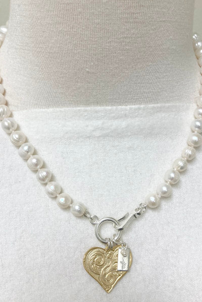 Mary Kate Pearl Necklace by Pearly Girls, featuring ring pearls and a gold etched heart pendant. This necklace elegantly pairs the distinctive texture of ring pearls with a romantically etched gold heart pendant, creating a blend of classic pearl beauty and a touch of heartfelt charm.