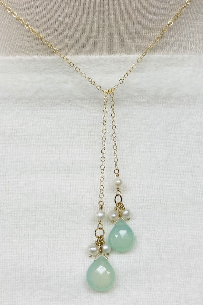 Dainty Chalcedony and Pearl Lariat by Pearly Girls, featuring a gold-filled chain and soft green chalcedony. This lariat necklace elegantly combines the delicate luminosity of pearls with the serene green hue of chalcedony, strung on a graceful gold-filled chain for a refined and gentle look.