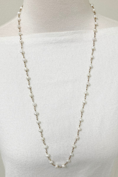 Sydney Pearl Necklace by Pearly Girls, featuring freshwater pearls strung on antique brass. This necklace artfully combines the timeless elegance of pearls with the vintage charm of an antique brass setting, creating a piece that blends classic beauty with a touch of historical allure.