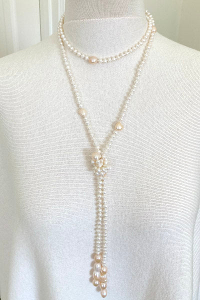 Blush Pearl Lariat by Pearly Girls, a versatile piece featuring white and blush baroque pearls. This lariat-style necklace gracefully combines the unique charm of baroque pearls in soft white and blush tones, offering flexibility and elegance for various styles and occasions.