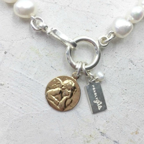 Rosie Pearl Bracelet by Pearly Girls, adorned with a cherub charm and freshwater pearls. This bracelet pairs the timeless elegance of pearls with a playful cherub charm, creating a whimsical and charming piece that combines classic beauty with a touch of angelic whimsy.
