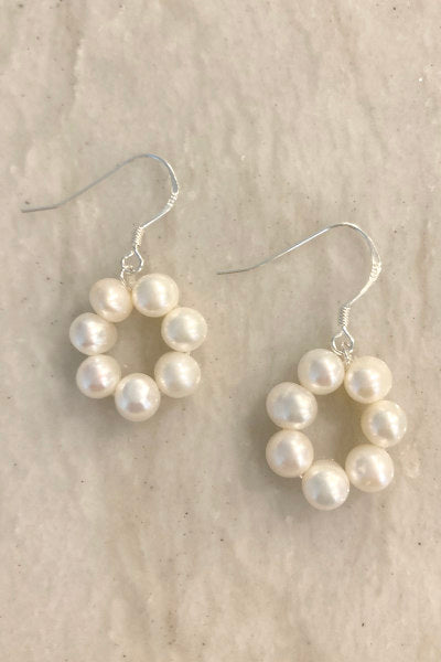 Pearl Circle Earrings by Pearly Girls, combining freshwater pearls with sterling silver. These earrings feature a graceful circle design, adorned with lustrous freshwater pearls, set in sterling silver, creating a harmonious blend of classic elegance and contemporary geometric style.