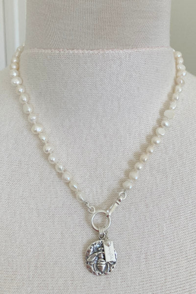 Lydia Silver Pearl Necklace by Pearly Girls, featuring a bee motif and freshwater pearls. This necklace harmoniously combines the natural elegance of freshwater pearls with a charming silver bee motif, creating a piece that is both stylish and symbolic of nature's beauty.