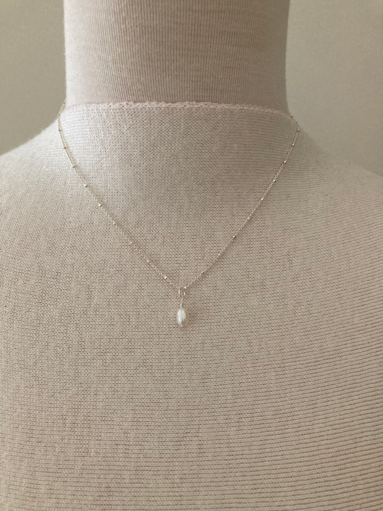 Dainty Pearl Necklace Silver by Pearly Girls, featuring a timeless pearl drop on a sterling chain. This necklace presents a classic pearl drop pendant, gracefully suspended from a fine sterling silver chain, embodying simplicity and elegance in a versatile and enduring design.