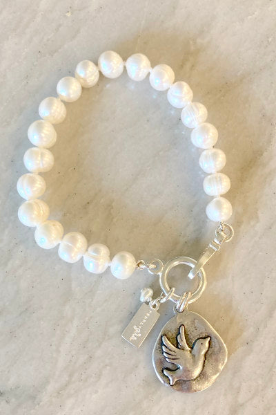 Hope Pearl Bracelet by Pearly Girls, featuring ring pearls and a sterling silver bird charm. This bracelet combines the distinctive texture of ring pearls with a delicate sterling silver bird charm, symbolizing freedom and aspiration, creating an accessory that's both elegant and meaningful.